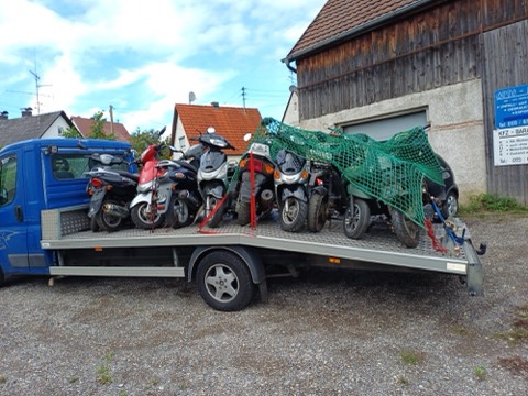 Mehrere Roller und Motorroller auf der Ladefläche